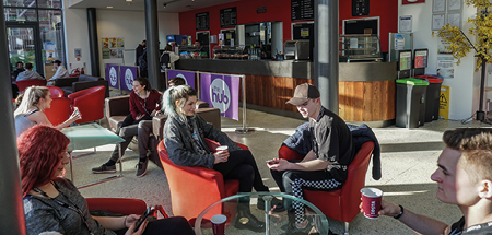 Students relax with coffee inside the sunny café