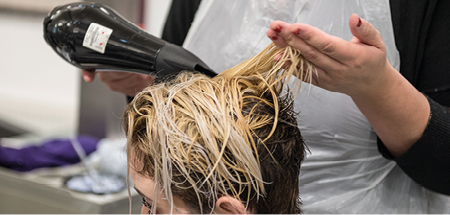 Close-up of a student blow drying short hair
