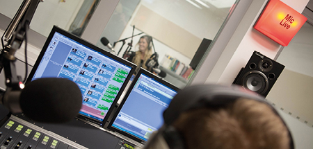 Students working in the radio studio with a mic live sign lit up