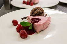 Beautifully plated pink desert with chocolate ice cream, raspberries and sauce