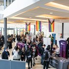 The Hub, filled with exhibition stands, with students circulating and talking to people at the stands