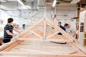 Students work on a large scale model of roof joists