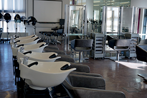Series of photos showing large hair salon with row of sinks for washing hair and mirrored stations for cutting, colouring and styling