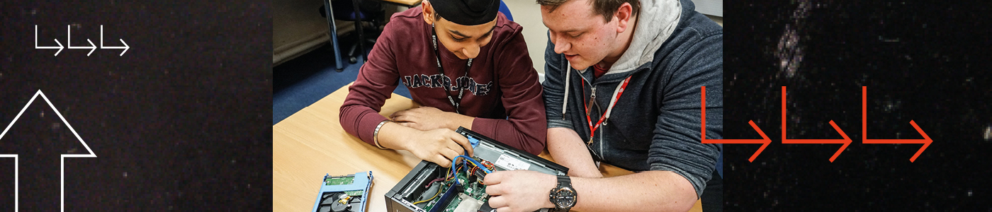 2 students work on the inside of a computer, you can see the internal components and they are connecting wires