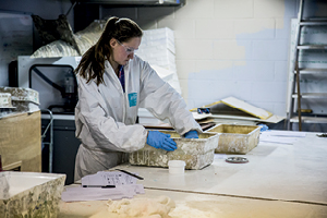 A student at a workbench constructing with glass fibre