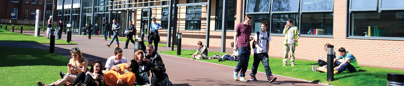 Students enjoy the sunshine outside the college buildings